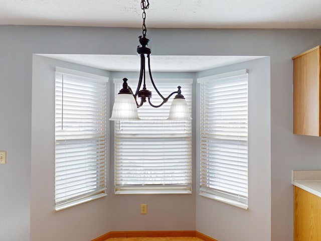 unfurnished dining area featuring an inviting chandelier and a wealth of natural light