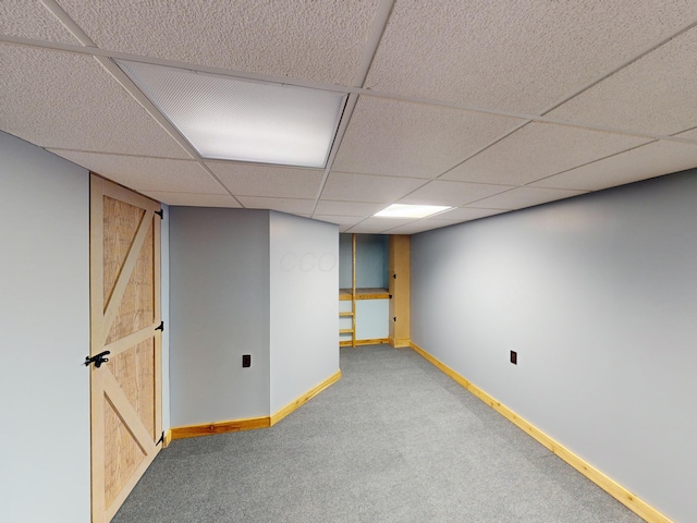 basement with carpet floors and a drop ceiling