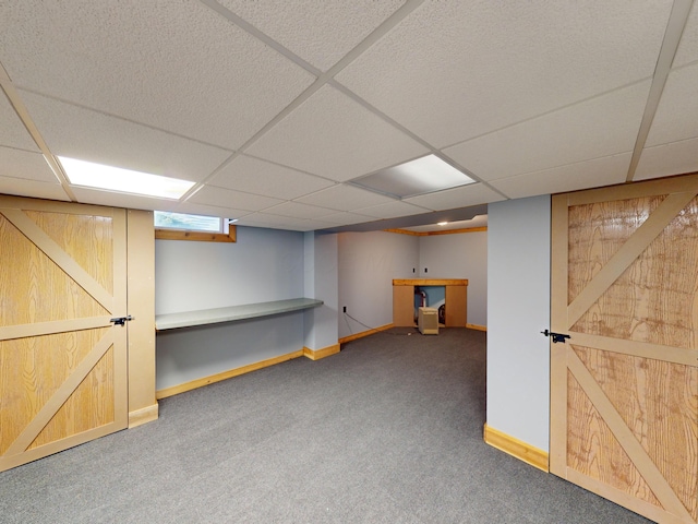 basement featuring carpet and a drop ceiling