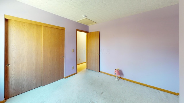 unfurnished bedroom featuring light carpet, a closet, and a textured ceiling