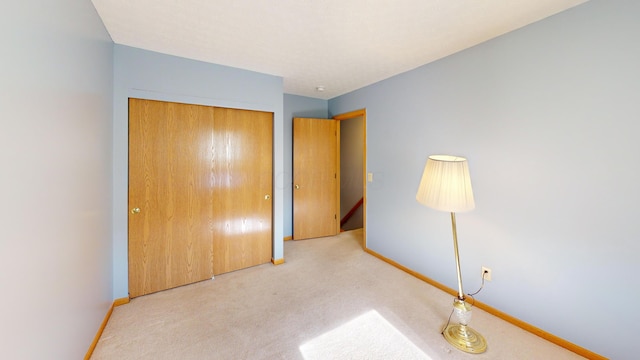 unfurnished bedroom with light carpet and a closet