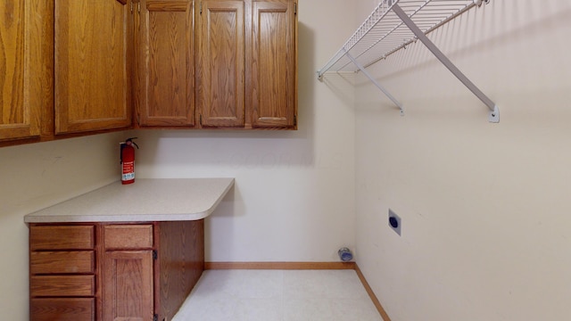 washroom with electric dryer hookup and cabinets