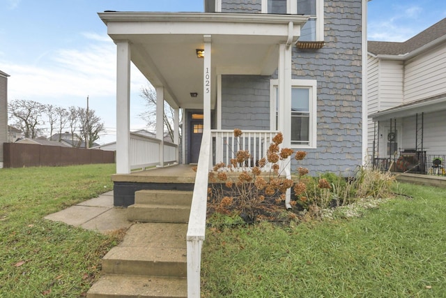 property entrance featuring a porch and a yard