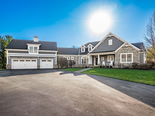 craftsman house featuring a front yard, a garage, and covered porch