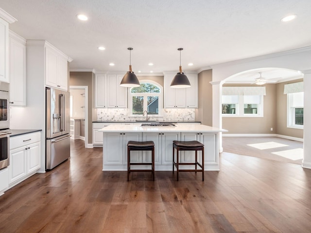 kitchen with a center island, white cabinetry, ceiling fan, pendant lighting, and appliances with stainless steel finishes