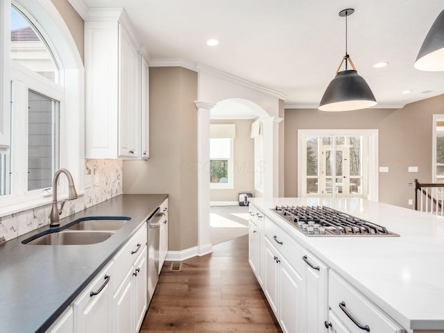 kitchen featuring stainless steel appliances, ornate columns, white cabinets, and sink