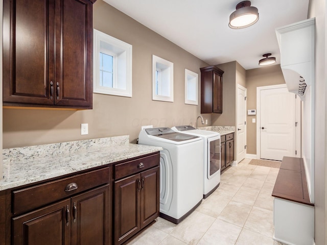 laundry area featuring light tile patterned flooring, cabinets, separate washer and dryer, and sink