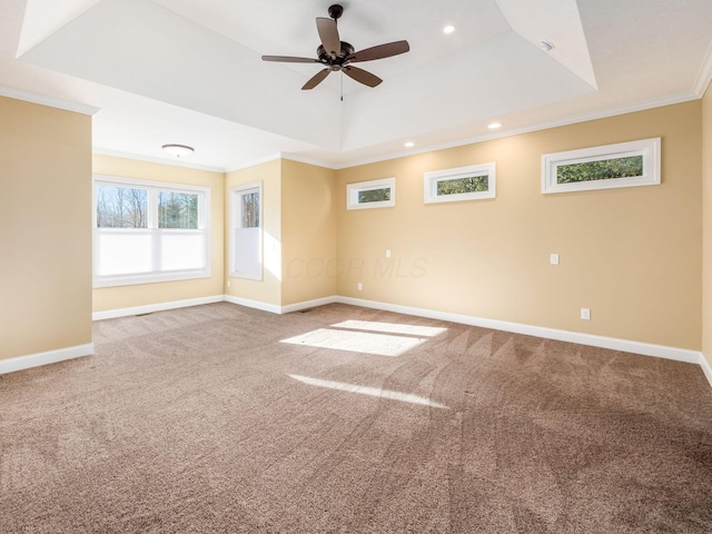 empty room with ceiling fan, carpet, crown molding, and a tray ceiling