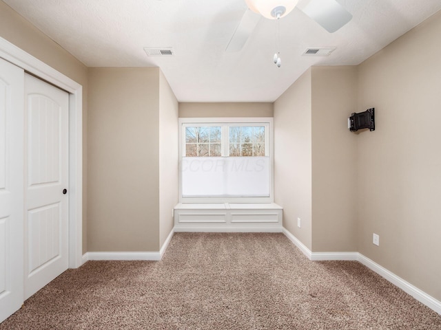 interior space with a closet, ceiling fan, and carpet