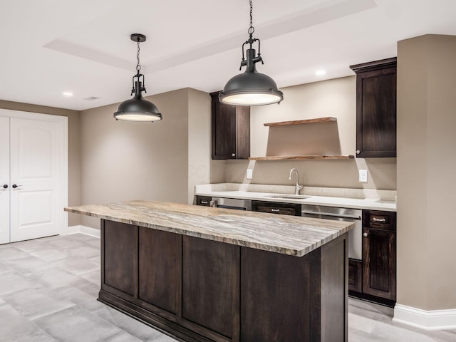 kitchen with sink, pendant lighting, dark brown cabinets, and a tray ceiling