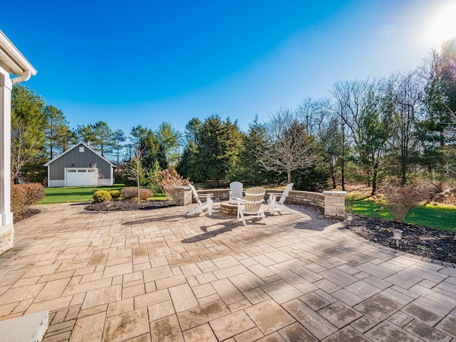 view of patio with a fire pit and a garage