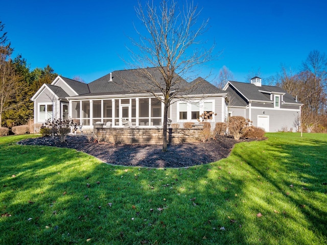 rear view of property featuring a yard and a sunroom