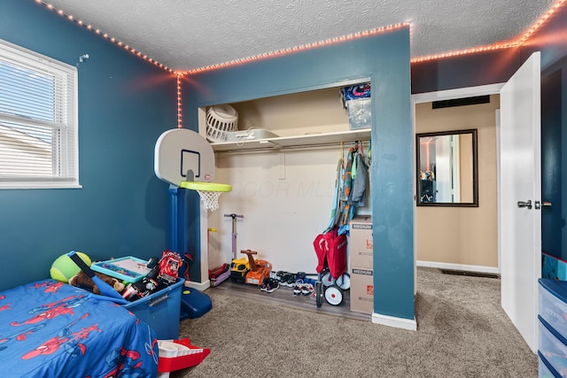 carpeted bedroom with a textured ceiling and a closet