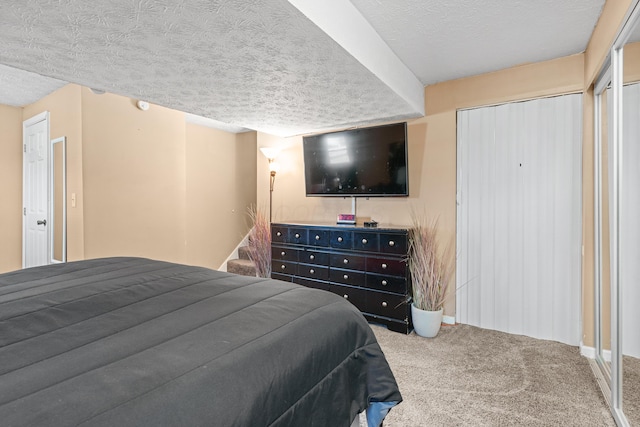 carpeted bedroom with a textured ceiling and a closet