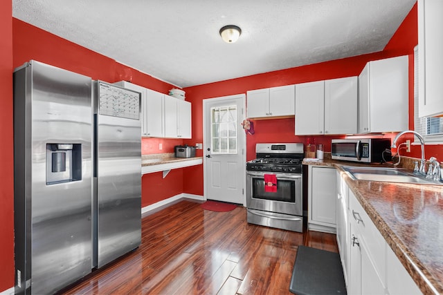 kitchen featuring sink, dark hardwood / wood-style flooring, stone countertops, white cabinets, and appliances with stainless steel finishes