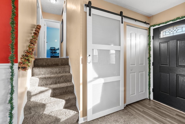 foyer entrance featuring a barn door and hardwood / wood-style flooring