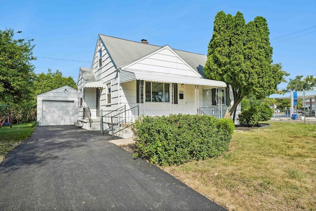 view of front of home with a front yard, a garage, and an outdoor structure