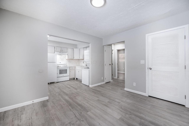 kitchen with decorative backsplash, white appliances, light wood-type flooring, a textured ceiling, and white cabinets