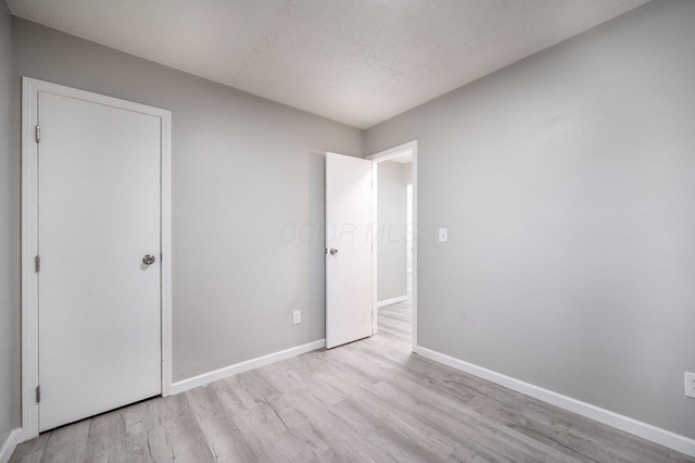 unfurnished bedroom featuring light hardwood / wood-style floors and a textured ceiling