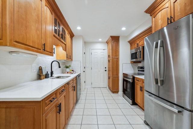 kitchen featuring backsplash, light tile patterned floors, sink, and appliances with stainless steel finishes