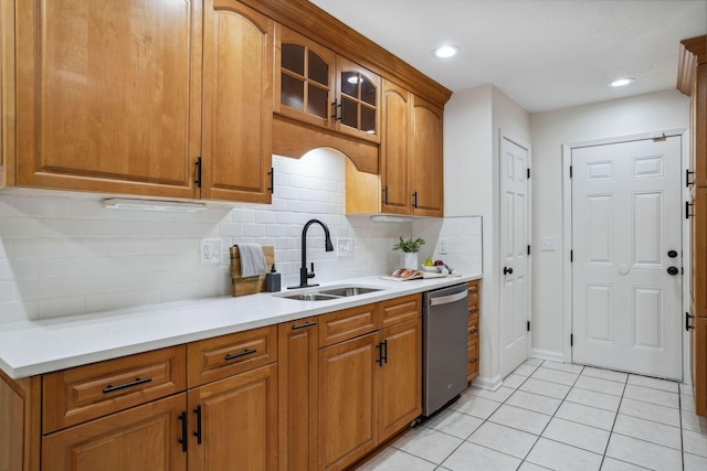 kitchen with tasteful backsplash, dishwasher, sink, and light tile patterned flooring