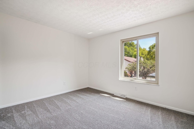 carpeted empty room with a textured ceiling