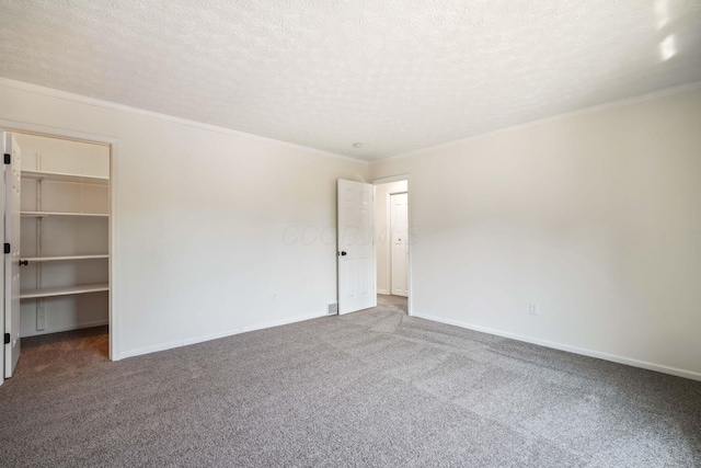 carpeted empty room featuring a textured ceiling and crown molding