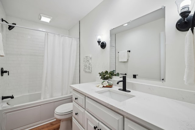 full bathroom with hardwood / wood-style flooring, vanity, shower / tub combo, and toilet