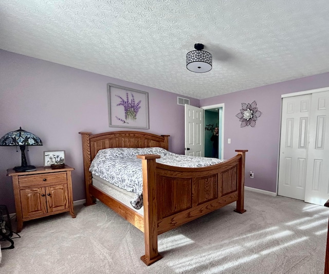 carpeted bedroom with a closet and a textured ceiling