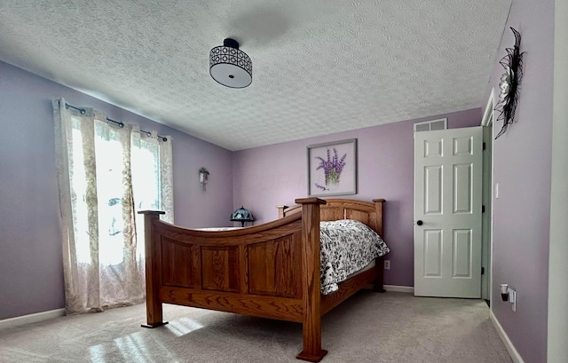 bedroom with light colored carpet and a textured ceiling