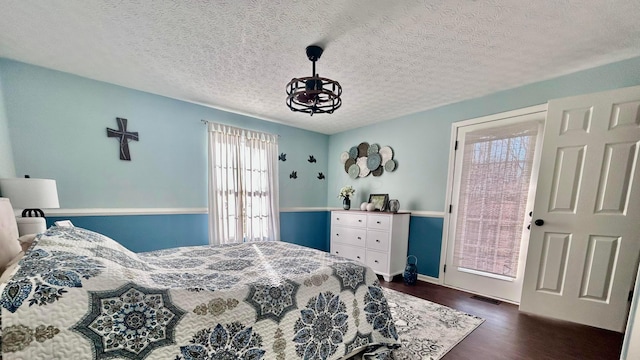 bedroom featuring a textured ceiling and dark hardwood / wood-style floors