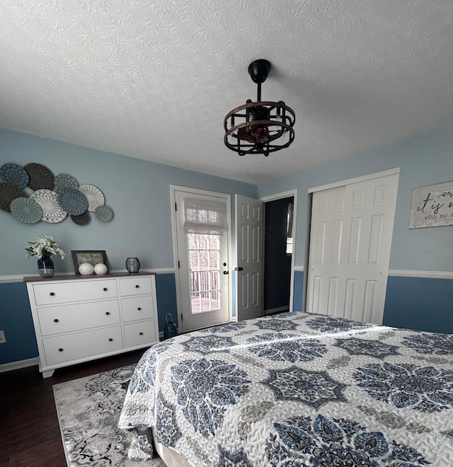 bedroom with a textured ceiling, dark wood-type flooring, and a closet