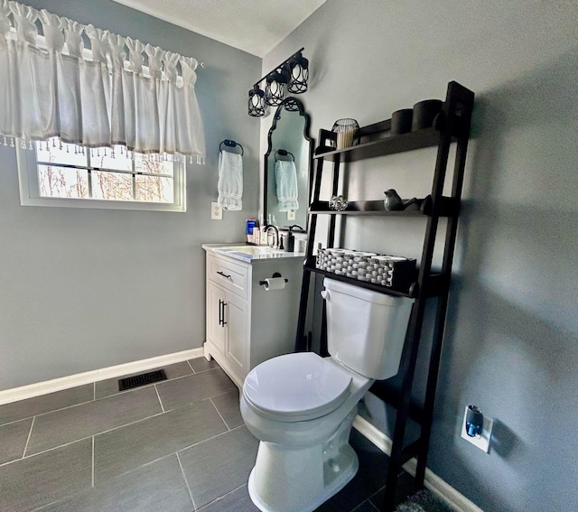 bathroom featuring tile patterned flooring, vanity, and toilet