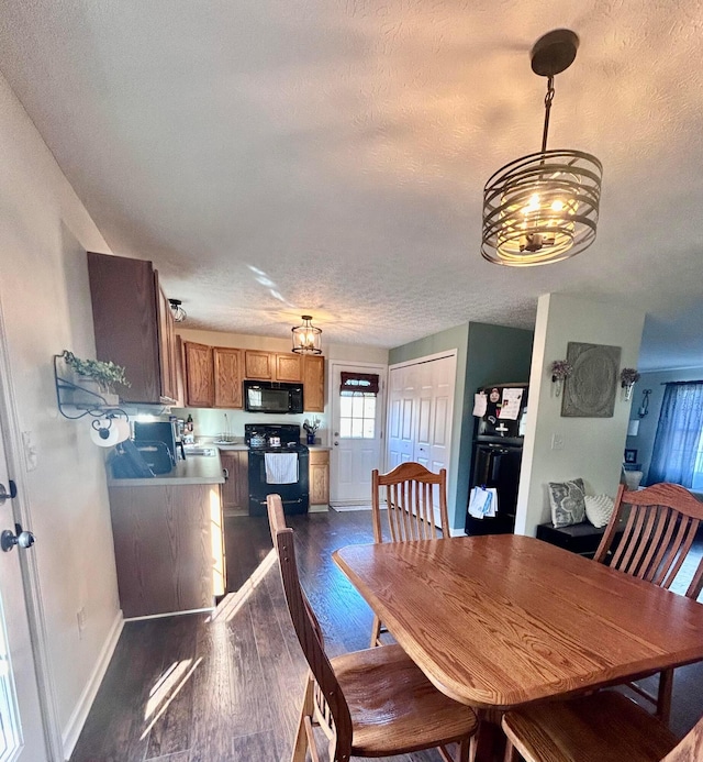 dining room featuring dark hardwood / wood-style floors, a textured ceiling, and a chandelier