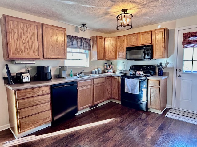 kitchen featuring sink, dark hardwood / wood-style floors, a wealth of natural light, and black appliances