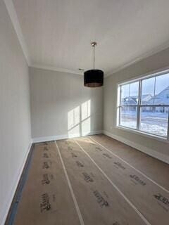 unfurnished dining area with baseboards and ornamental molding