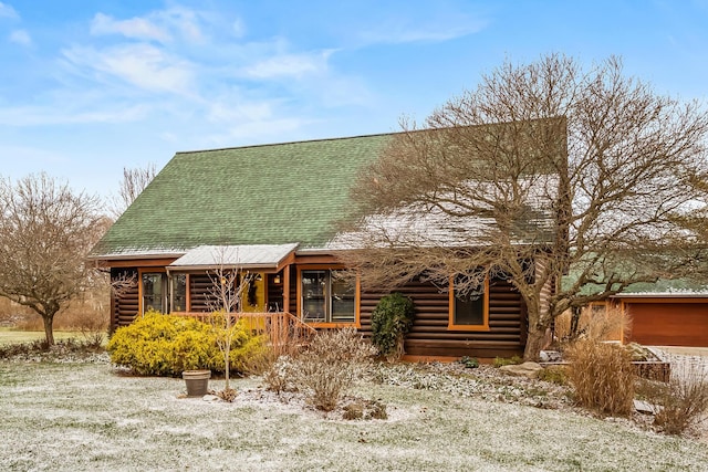 view of front of property featuring log exterior, a shingled roof, and a porch