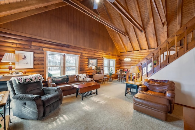 living room featuring stairs, carpet, beamed ceiling, and ceiling fan