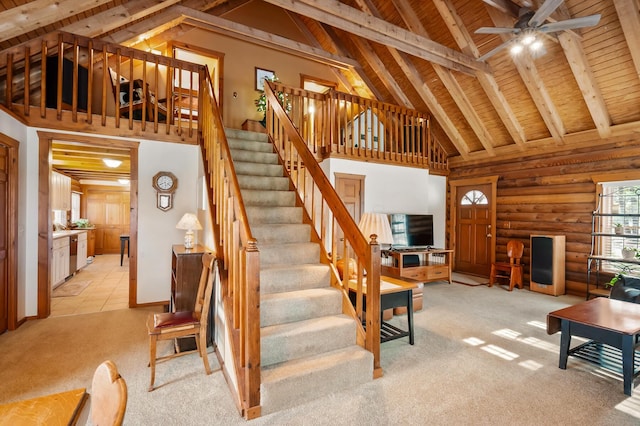 stairway with wooden ceiling, high vaulted ceiling, carpet flooring, and beamed ceiling