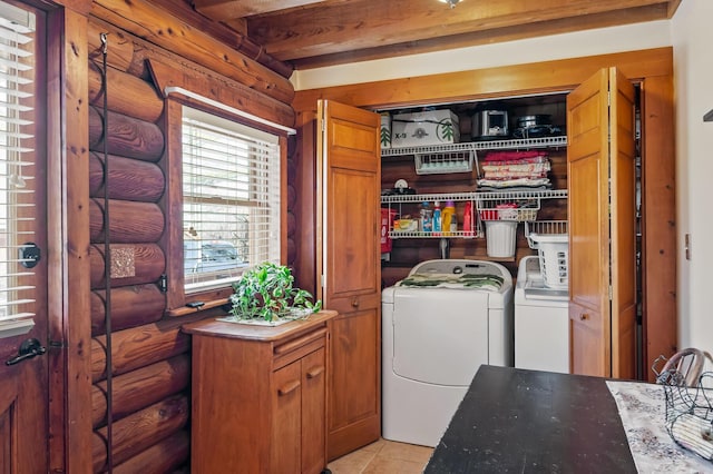 laundry area featuring light tile patterned floors, laundry area, rustic walls, and separate washer and dryer