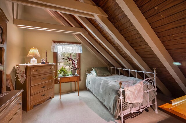 bedroom featuring vaulted ceiling with beams and light colored carpet