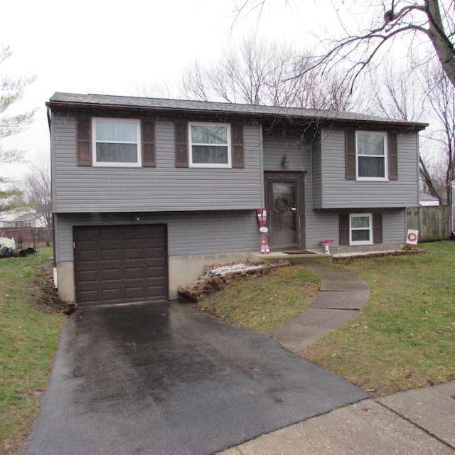 bi-level home with a garage and a front lawn