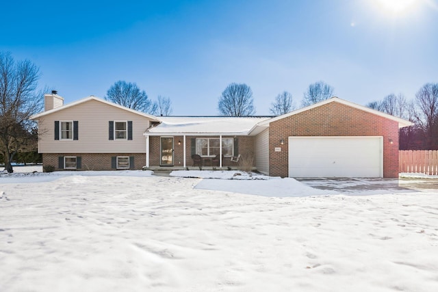 split level home featuring a garage and covered porch