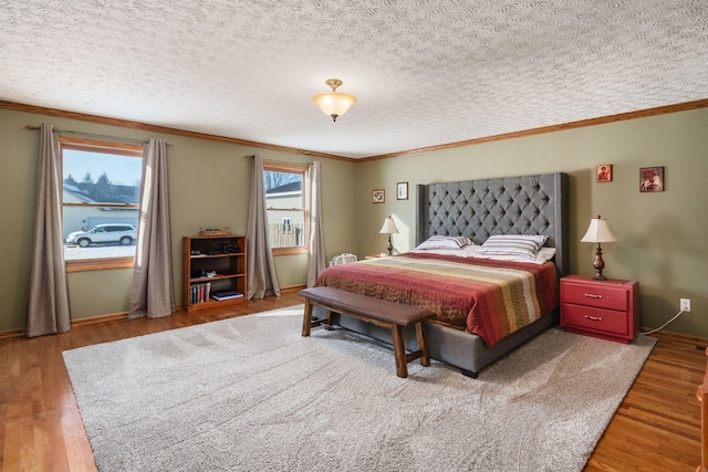 bedroom with hardwood / wood-style floors, a textured ceiling, and crown molding