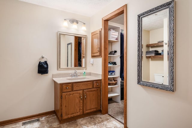 bathroom featuring a textured ceiling and vanity