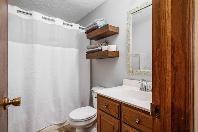 bathroom with vanity, toilet, and a textured ceiling