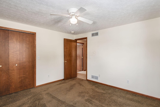 unfurnished bedroom featuring carpet, a textured ceiling, a closet, and ceiling fan