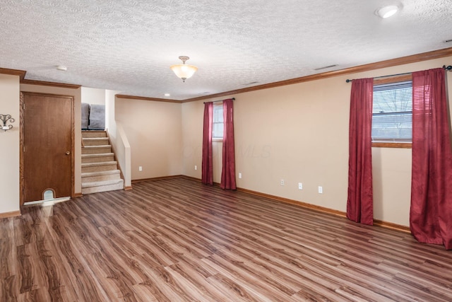 unfurnished living room with ornamental molding, hardwood / wood-style floors, and a textured ceiling