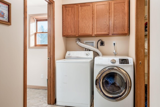 clothes washing area featuring cabinets and washing machine and dryer