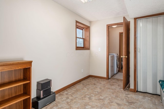 interior space with washing machine and clothes dryer and a textured ceiling